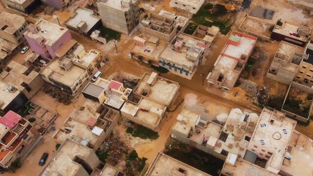 Drone pulls back in top-down view over Dakar informal residential neighborhood
