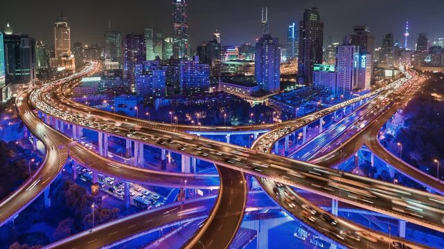 Zoom out pan up time lapse of busy elevated road intersection with commuters with neon lighting, at night, Asia, China, Shanghai