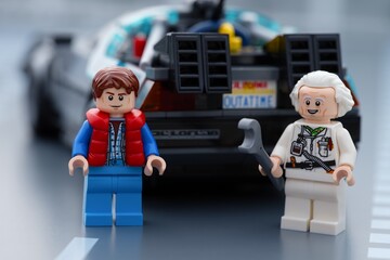 Obraz premium Tambov, Russian Federation - June 20, 2026 Lego minifigures of Marty McFly and Doc Brown standing in front of the DeLorean time machine car from Back to the Future.