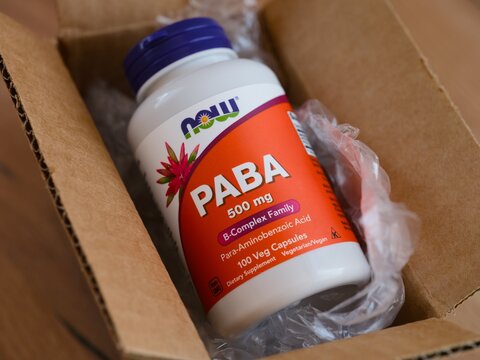 Tambov, Russian Federation - May 22, 2026 A plastic bottle of NOW PABA dietary supplement packed inside a cardboard shipping box with clear bubble wrap.
