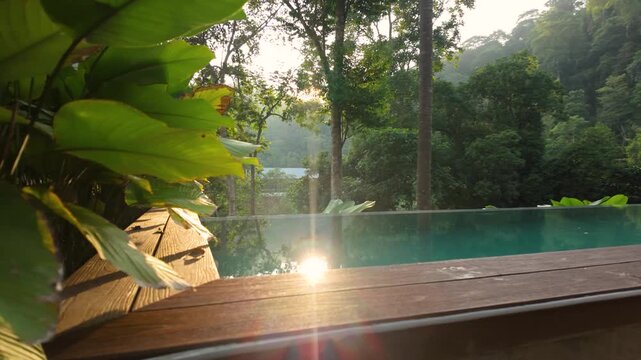 Sunlit infinity pool surrounded by lush tropical rainforest, with vibrant green foliage and warm morning light creating a serene luxury retreat in nature