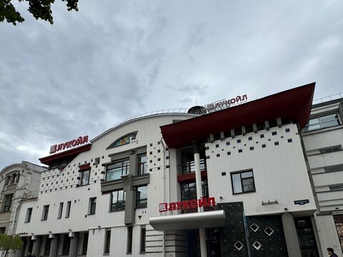 Russia Nizhny Novgorod 28 june lukoil building in urban area with neutral street-level perspective and concrete and glass materials, white and red colors, commercial real estate context, neutral mood.