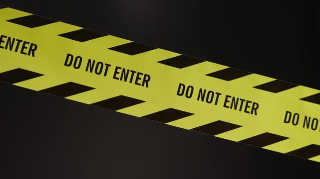 The focus shifts from a blur to a "Do Not Enter" barrier tape, marking a restricted and dangerous zone&mdash;such as a murder scene or an active investigation area&mdash;where entry is strictly prohibited.