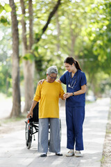 Fototapeta premium Healthcare professional supporting an elderly patient walking outdoors during rehabilitation, providing assistance and encouragement for improved mobility and wellbeing