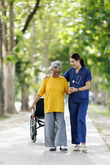 Obraz premium Nurse assisting elderly woman in rehabilitation walk outdoors, providing physical therapy and compassionate support, promoting health, well-being, and senior care services in a park setting