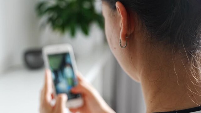Woman scrolling social media on a smartphone at home. Digital addiction concept with endless content consumption and screen time.