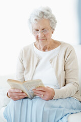 Obraz premium Calm, book or old woman in house with reading, fantasy novel or insight in literature activity. Relax, glasses or senior person with fairytale, peaceful moment or fiction story in retirement hobby.