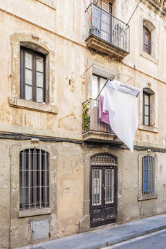 Hanging White Laundry on Balcony of Old Rustic Building Facade, Vintage Residential House, Aged Wall, Barcelona