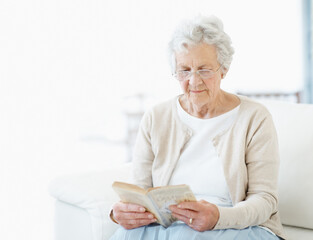 Obraz premium Calm, book or old woman on couch with reading, fantasy novel or insight in literature hobby. Space, glasses or senior person in house with fairytale, peaceful moment or fiction story in retirement.