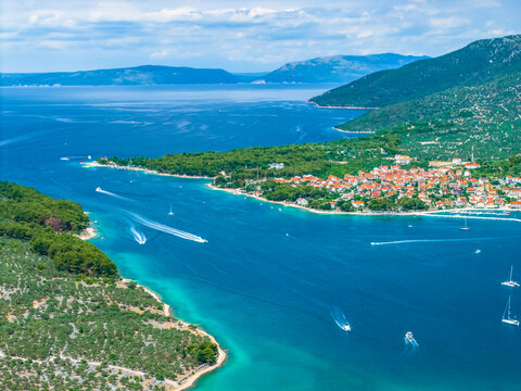 Aerial view of boats sailing around green coastline, Cres island. Travel to Croatia