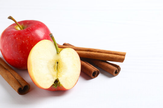 Apple with cinnamon sticks on white background. Space for text