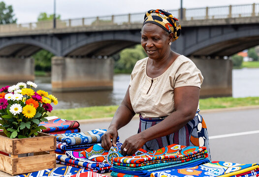 African Woman Selling Colorful Fabrics at Outdoor Market