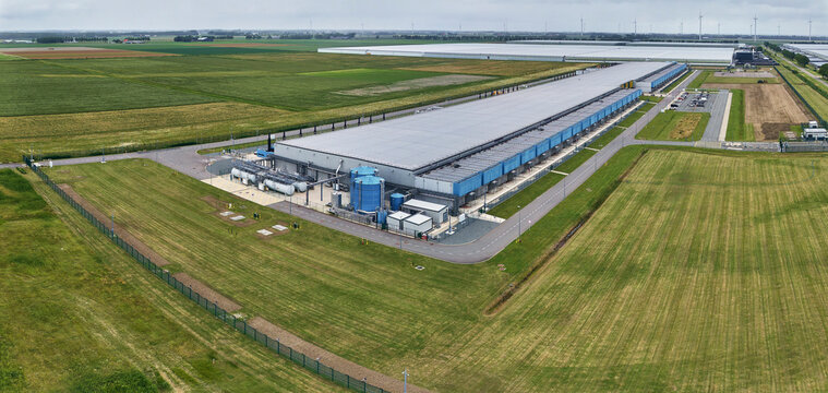 Data center infrastructure and cloud computing, aerial view of Google data center at Agriport in Middenmeer, Netherlands, wind turbines, green field