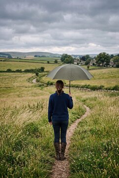 Rear View of Woman Holding Umbrella in Field