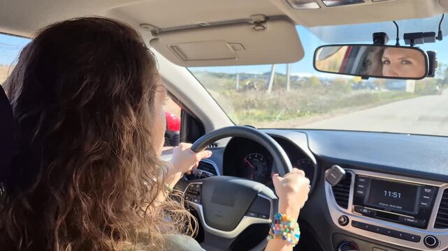 Driving, road trip, woman navigating a sunny road in a modern car during a relaxing summer journey.