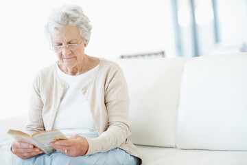 Obraz premium Relax, book or old woman in lounge with reading, fantasy novel or insight in literature hobby. Chill, glasses or senior person in house with fairytale, peaceful moment or fiction story in retirement.