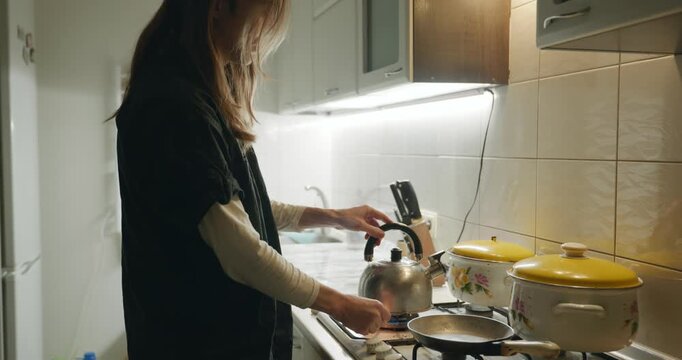 Caucasian man drink hot water in evening. Single male is drinking tea at kitchen at home. 4K 10-bit