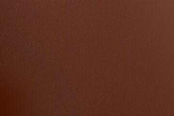 Fototapeta premium Rich brown texture dominates image. Subtle grain visible, suggesting material like leather or fabric. Warm tones present throughout.