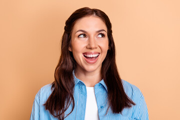 Fototapeta premium Smiling happy woman looking up in casual portrait with peach background, cheerful expression and natural makeup for lifestyle, emotion and positive concept imagery