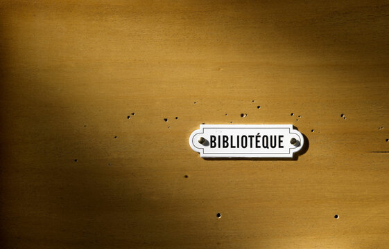 Wooden board texture with a plaque saying: library