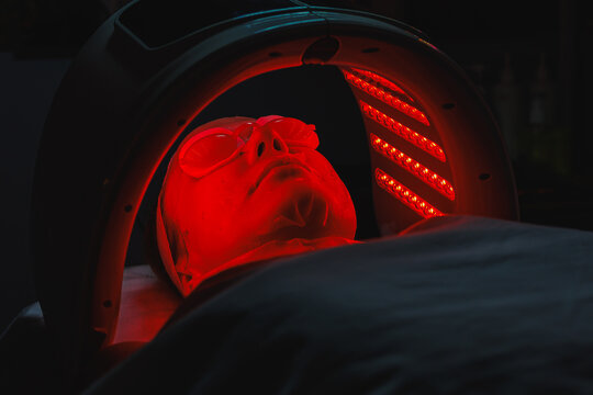 Cosmetology appointment for a woman receiving red light therapy treatment in a beauty salon during the afternoon for skin health and rejuvenation