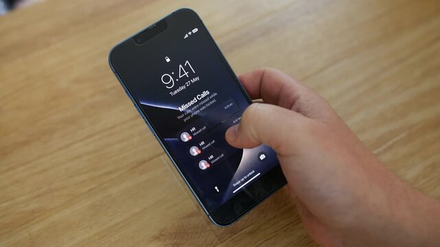 Missed calls from HR are displayed on a smartphone lock screen as a hand prepares to unlock the device. Close-up workplace communication scene highlighting recruitment, employee contact, and urgent bu