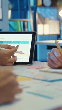 Vertical Screen : Close-up asia business people meeting plan analysis statistics brainstorm header of team hold tablet pointing graph chart and employee take note. Finance strategy statistics success.