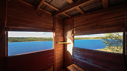 Fototapeta premium Wooden observation tower interior view through open windows across northern Swedish water
