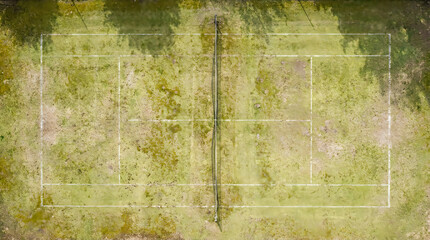 Naklejka premium Aerial view of a worn green tennis court surface with white boundary lines