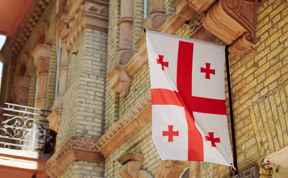 Georgia flag hanging on an old brick building facade.