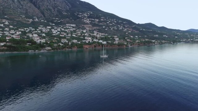Anchored Sailboat Near Verga Coastal Village by Kalamata, Greece, Morning Aerial View of Calm Blue Water, Mountain Shadow, Rocky Shoreline and Peaceful Mediterranean Bay