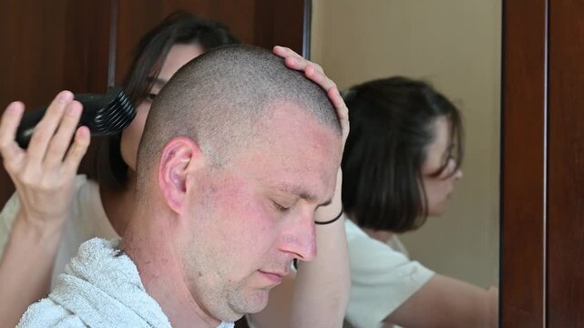 Woman Giving Her Husband a Buzz Cut at Home