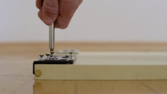 Skilled hands fix door mechanism. Experienced hands restore smooth sliding function. Weathered hands carefully adjust roller with screwdriver for proper door operation