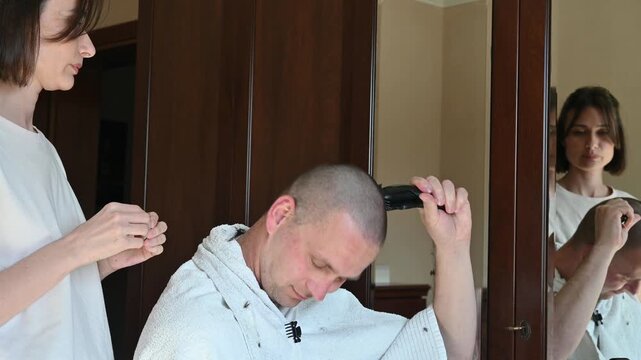 Woman Giving Her Husband a Buzz Cut at Home