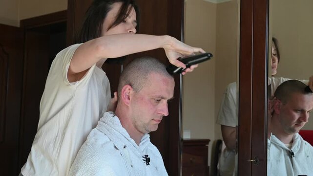 Woman Giving Her Husband a Buzz Cut at Home