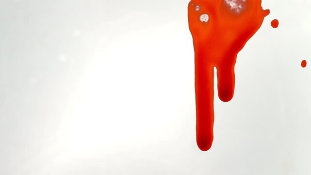 A cinematic close-up shot of blood flowing across a glass surface against a white background on the right side of the frame, revealing individual droplets&mdash;ideal for a thriller.