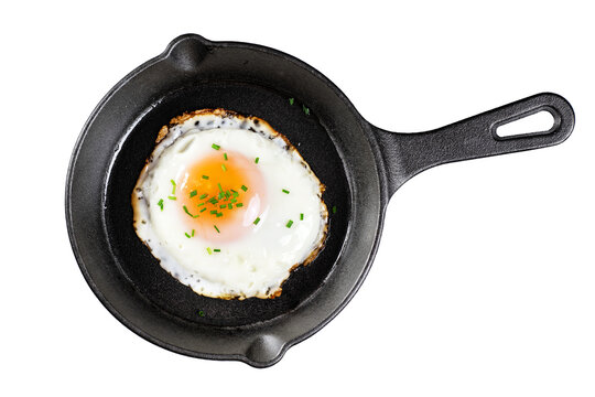 Fried egg with green onions on a cast iron mini frying pan isolated on a white background. With clipping path.
