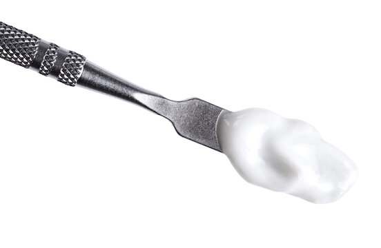 Cosmetic spatula with moisturizing cream isolated on white background.