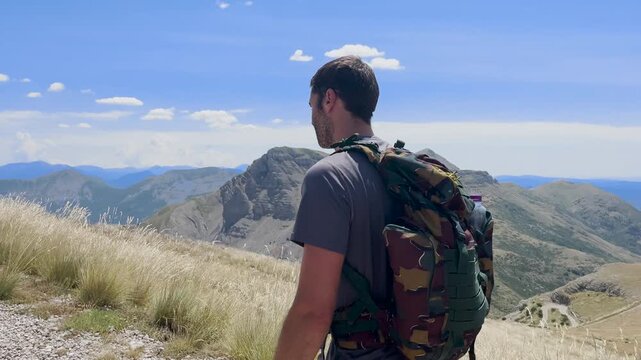 Randonneur qui avance sur un sentier de montage en direction du sommet du Mont Chiran et regarde le paysage au loin