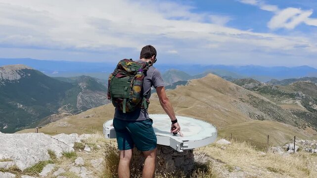 Randonneur qui arrive au sommet du Mont Chiran, &agrave; une table d'orientation