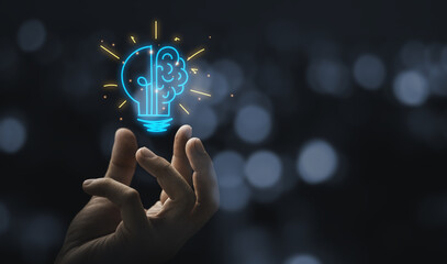 human hand holding a light bulb Hand holding drawing virtual lightbulb with brain on bokeh background for creative and smart thinking idea concept © Luis