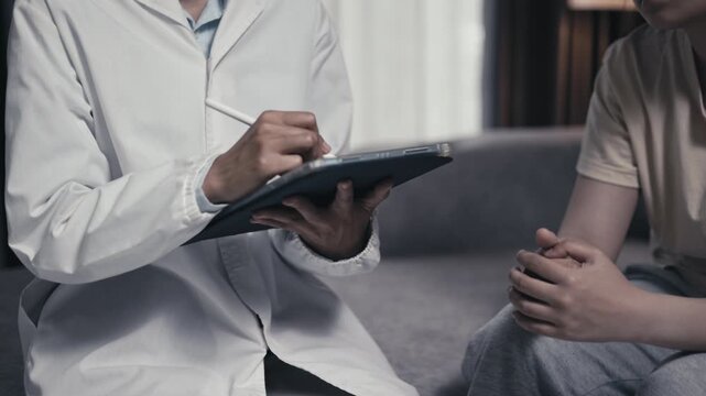 Mental health caregiver monitoring and recording symptoms of a teenager with depression. Counseling, emotional care, therapy, healthcare, recovery, hope, support, 4K.