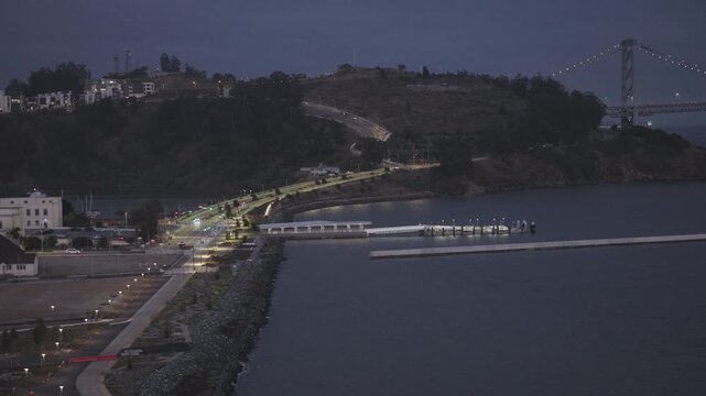 Coastal Waterfront and Pier at Dusk With Suspension Bridge Tower In San Francisco - Aerial Shot