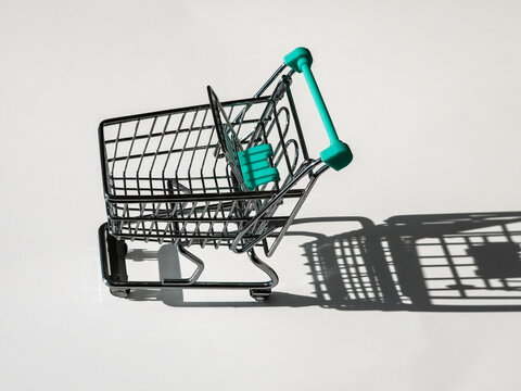 Empty miniature shopping cart on white background