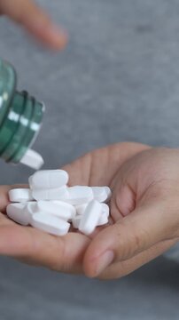 close up woman hand holding a medicine, with pours the pills out of the medicine bottle. Stop drug use Taking Medication Caring for the health care medical concept. capsule.	
