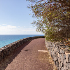 Fototapeta premium Stone promenade along the Atlantic coast at Esquinzo Beach, Fuerteventura, Canary Islands, Spain