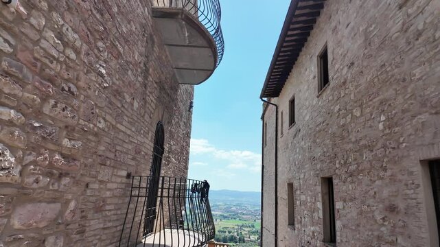 Narrow medieval passageway and archway between stone buildings in Assisi Italy