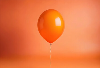 Fototapeta premium Orange balloon floating on orange background