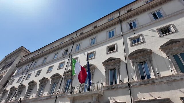 Historic facade of Palazzo Chigi with flags in Rome Italy