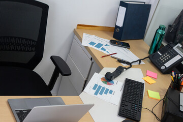Naklejka premium Busy office desk with laptop charts and stationery